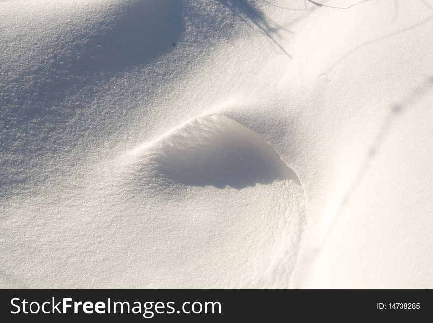 Shadows on a small snow drift.