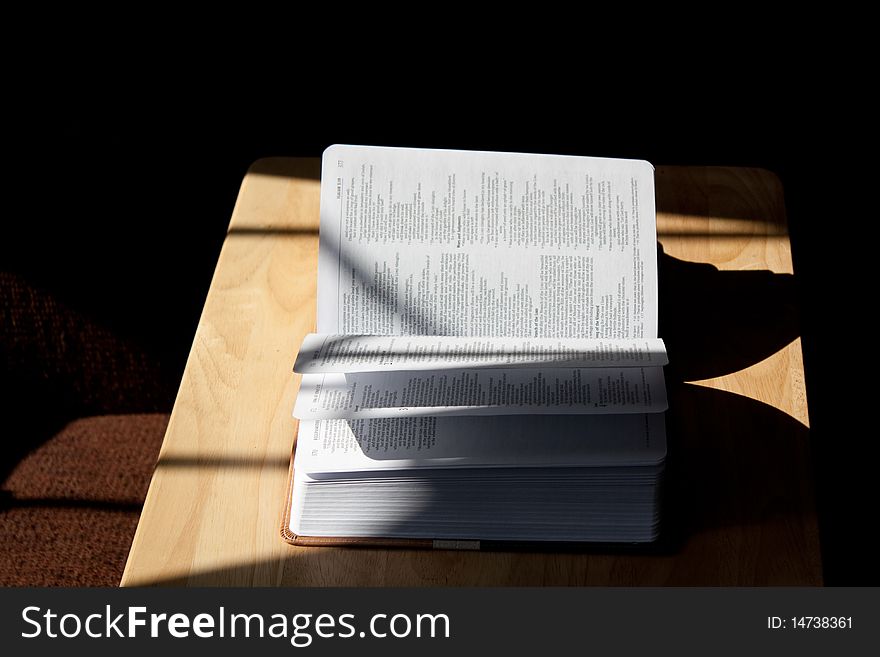 An open Bible in a shadow.