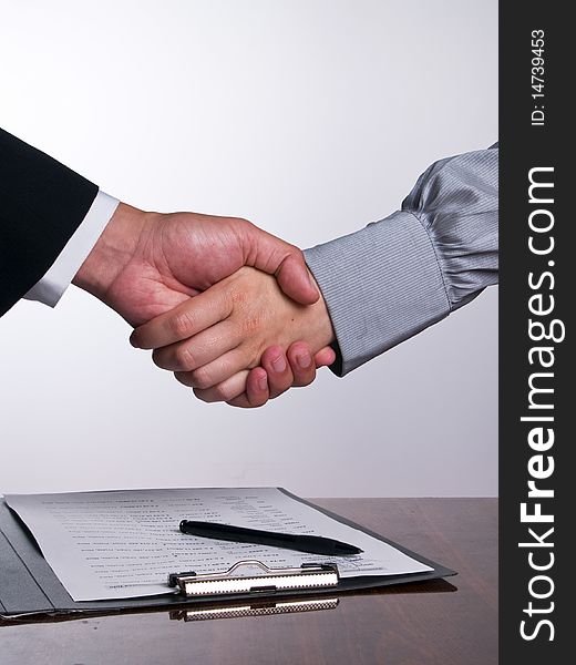 Business people in the office shaking hands after sign up the contract (vertical align). Business people in the office shaking hands after sign up the contract (vertical align)
