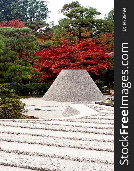 Red and green trees and a rock-garden in a Japanese autumn park. Red and green trees and a rock-garden in a Japanese autumn park