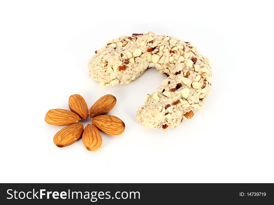 Homemade cake in shape of crescent with some almonds, isolated on white