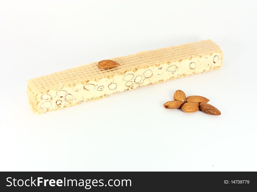 Almond nougat with some almonds, isolated on white. Almond nougat with some almonds, isolated on white