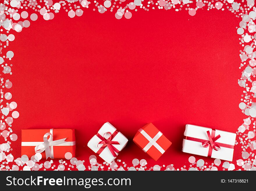 Gift boxes and colorful present for christmas on red background. Top view with copy space.