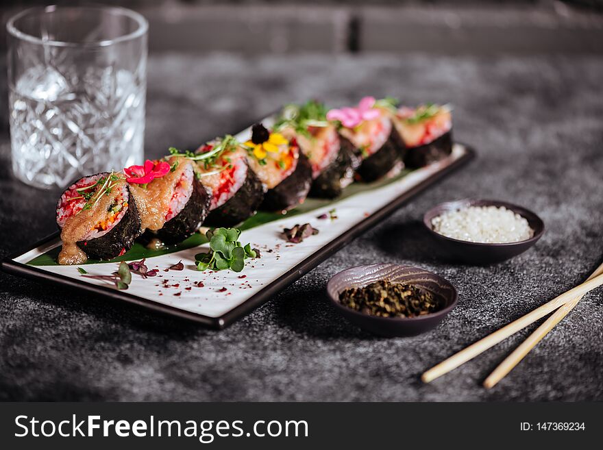 Various kinds of sushi served on black stone