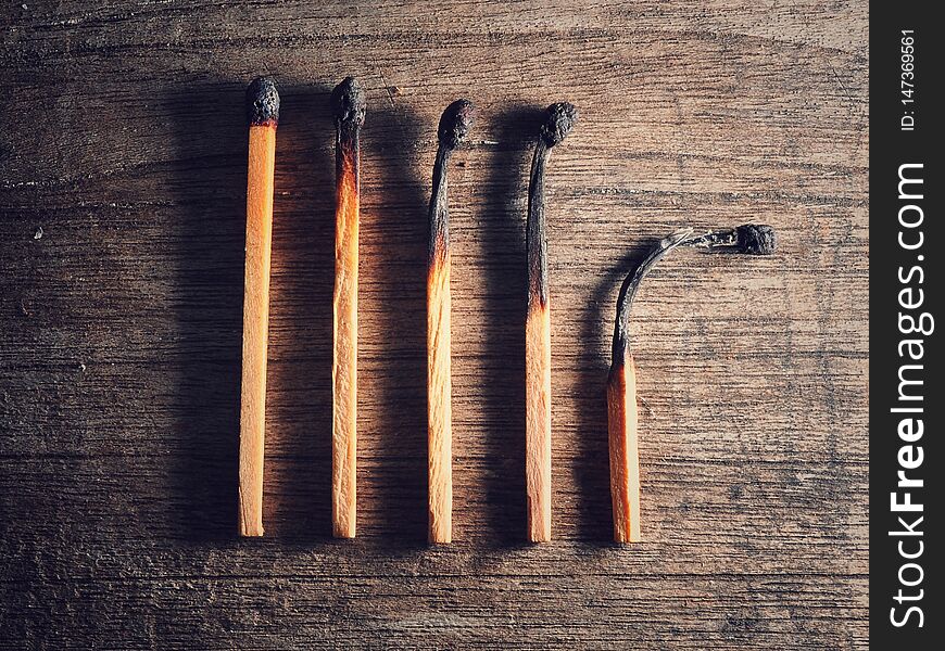 Different stages of match burning. Burnt matches isolated on wooden background. Creative background