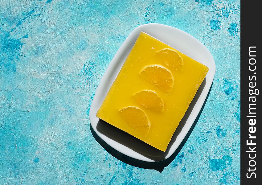 Yellow cheesecake with oranges on a bright blue background. Yellow cheesecake with oranges on a bright blue background.