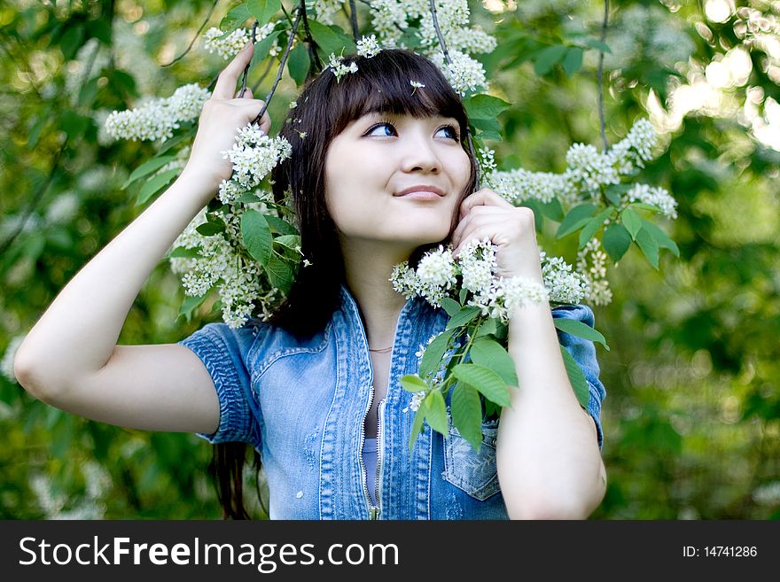 Girl standing near lilac in blossom