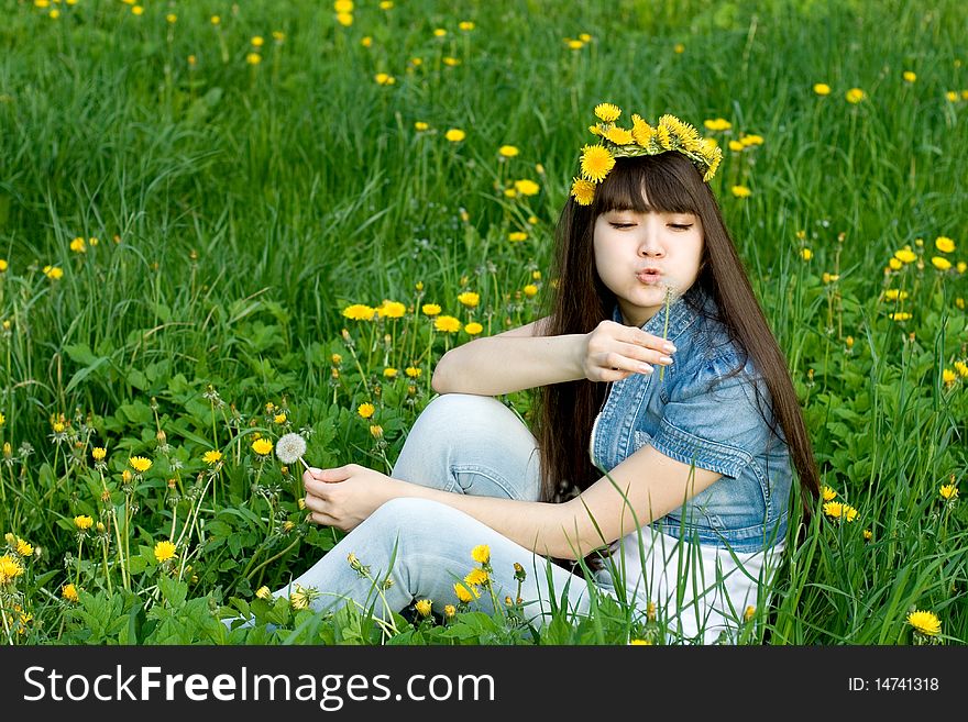 Girl sitting among dandelions