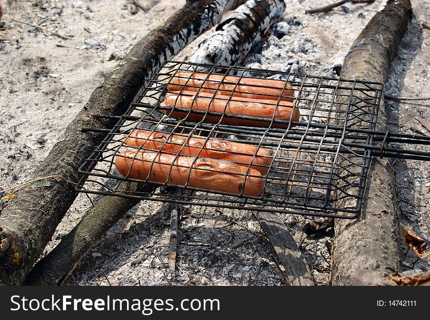 Fried sausages on the campfire