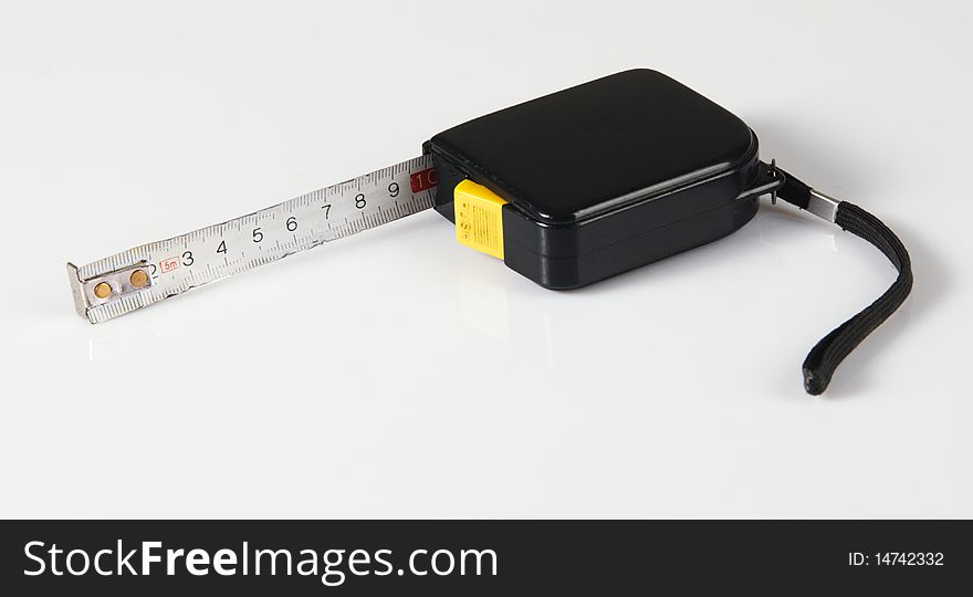 Tape measure on neutral background, closeup photo