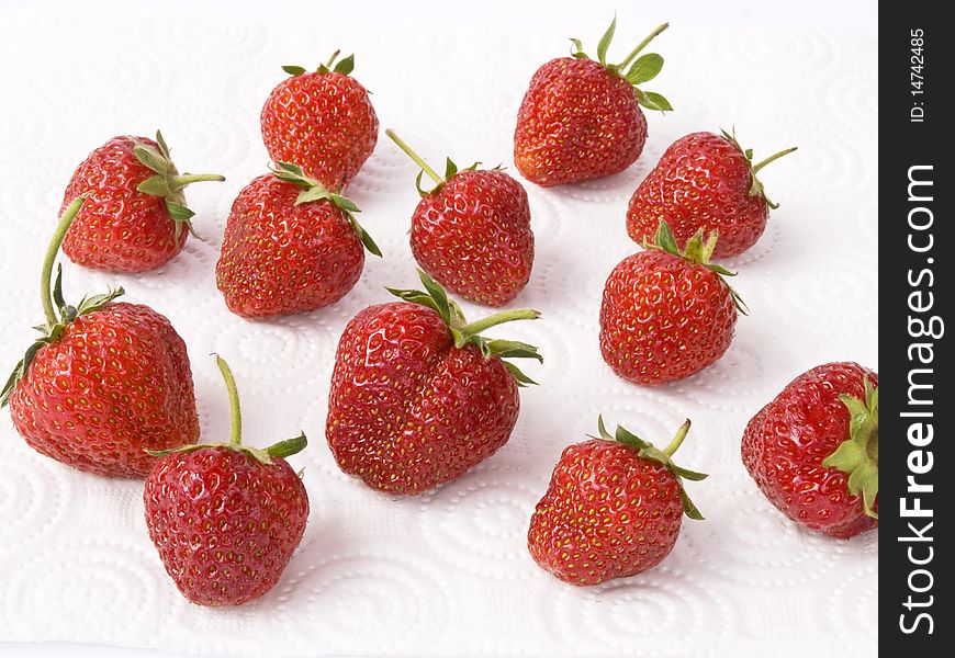 Ripe red strawberries on a white napkin under natural light. Ripe red strawberries on a white napkin under natural light