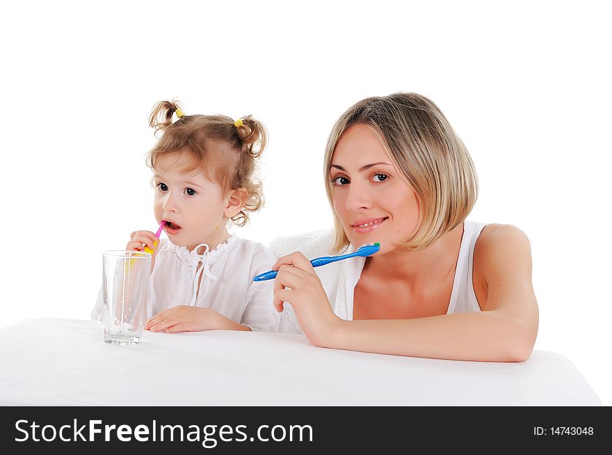 Young mother and her young daughter brush their teeth on a white background