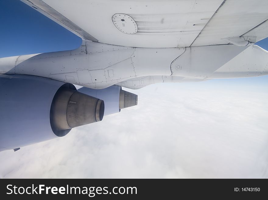 Shot of a Boeing wing at cruising altitude over clouds