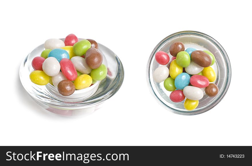 Multicolored shugar sweets in glass isolated on white background. Multicolored shugar sweets in glass isolated on white background