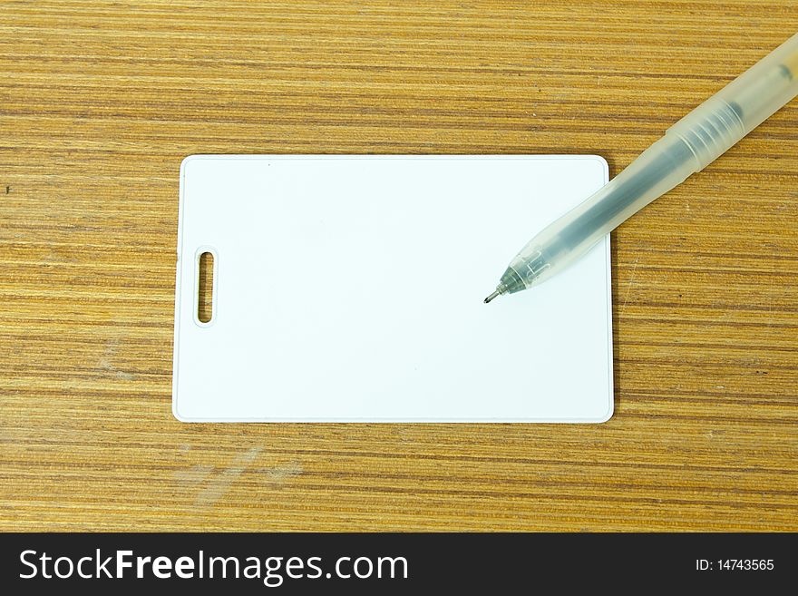 White card and the pen on the wood table. White card and the pen on the wood table