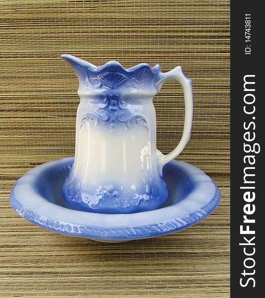 Blue pitcher and bowl set with straw background