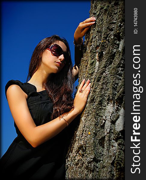 Charming Lady In Black Next To A Tree.