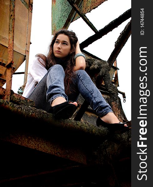 Beautiful girl sitting in an old factory.