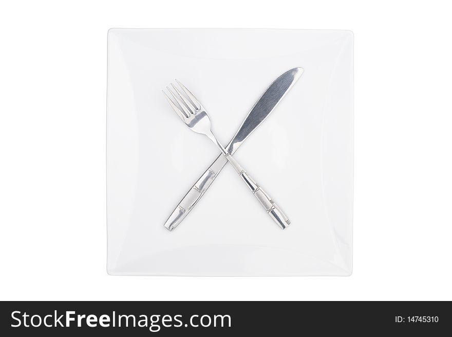 Fork and knife on a squared plate isolated. Fork and knife on a squared plate isolated