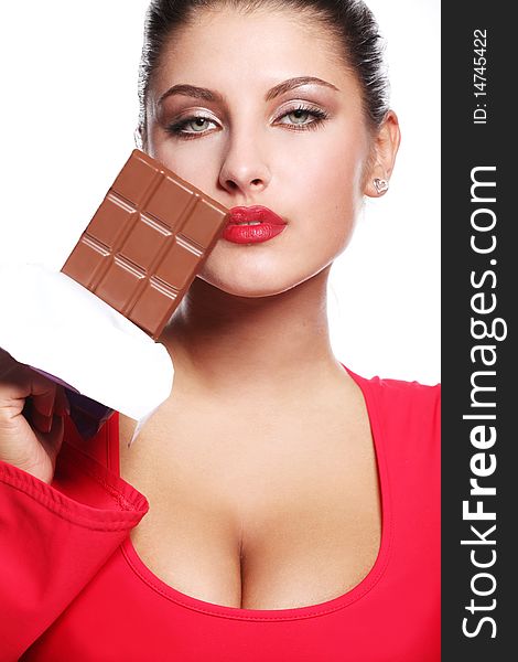 Young beautiful woman in red dress eating chocolate. Young beautiful woman in red dress eating chocolate