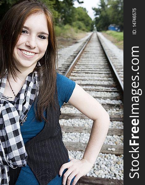 Teenager looking forward with railroad tracks behind her. Teenager looking forward with railroad tracks behind her