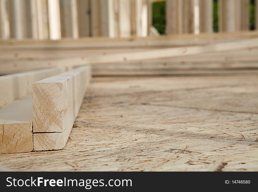 Boards laying on the foundation of a partially built house. Boards laying on the foundation of a partially built house