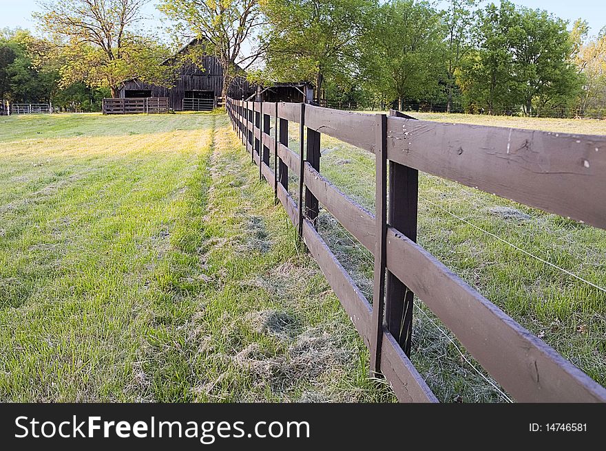 Fence line leads viewer to old A-frame barn in the background. Fence line leads viewer to old A-frame barn in the background