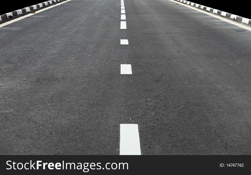 Shoot of empty road standing in the middle with white markings on it.