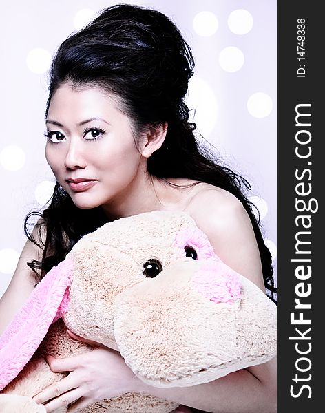 Long hair Asian girl holding a furry stuff animal and smiling to the camera. Long hair Asian girl holding a furry stuff animal and smiling to the camera