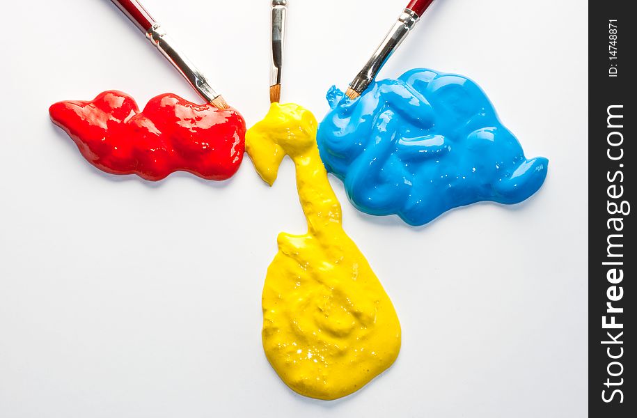 Paintbrushes and red, yellow and blue colors on a white background. Paintbrushes and red, yellow and blue colors on a white background