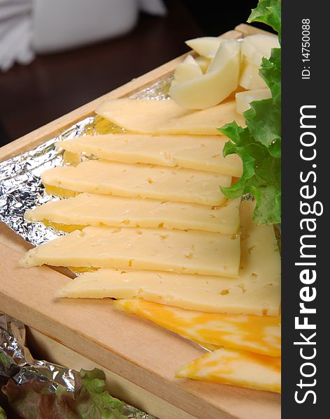 Dutch cheese on wooden plate. Closeup