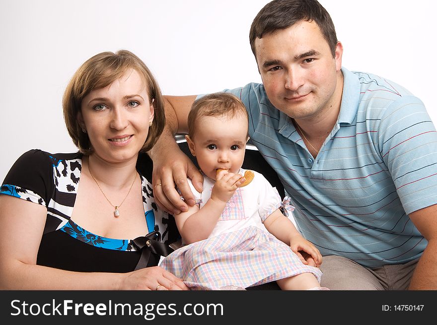 Happy family portrait of a baby with her parents over a white background