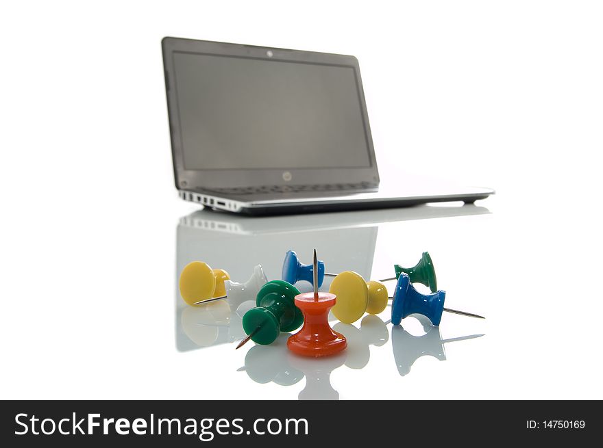 Several many-coloured thumbtacks and laptop over white background. Several many-coloured thumbtacks and laptop over white background