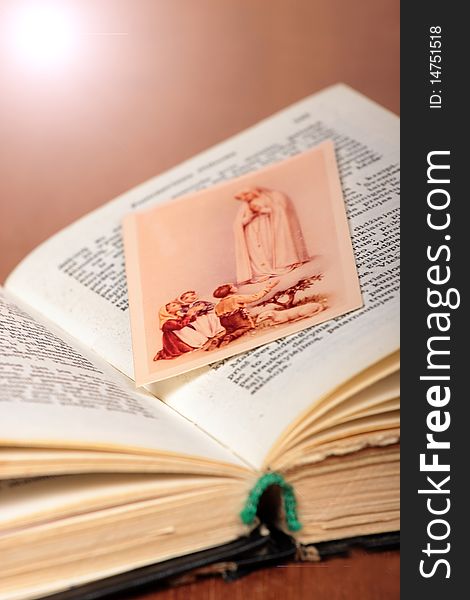 Little picture of children praying to Virgin Marry put between pages of old prayer-book. Little picture of children praying to Virgin Marry put between pages of old prayer-book