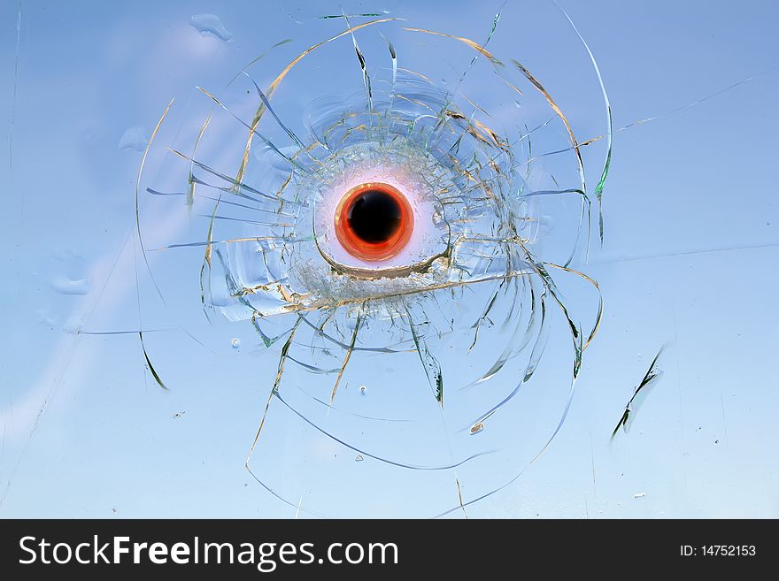 The heated steel bullet has got stuck in the broken automobile glass. The heated steel bullet has got stuck in the broken automobile glass