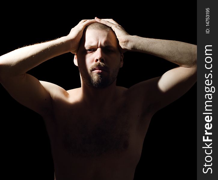 Portrait of bristly man enfolding a head in the dark