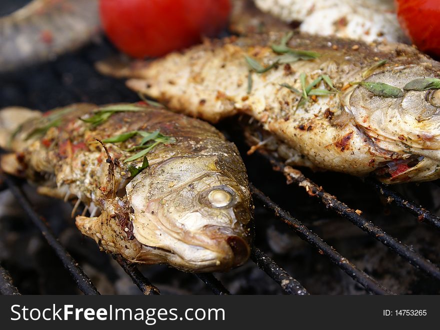 Carp with thyme and tomatoes on barbecue