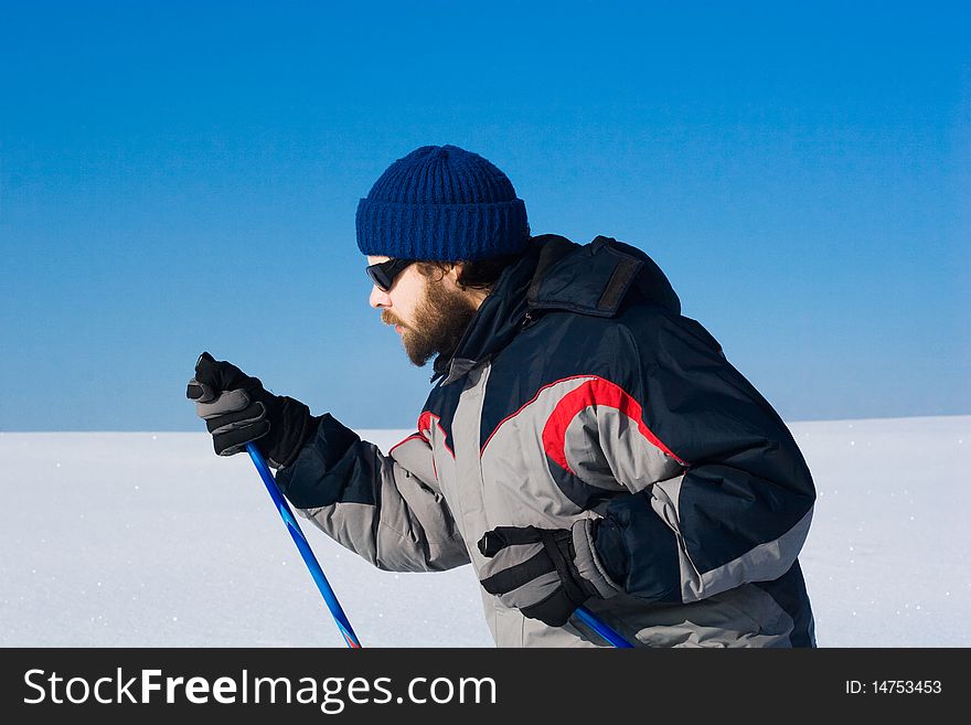 Portrait of handsome skier in the snowy field