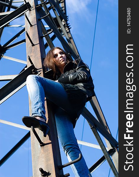 Beautiful woman climbing on electrical tower. Beautiful woman climbing on electrical tower