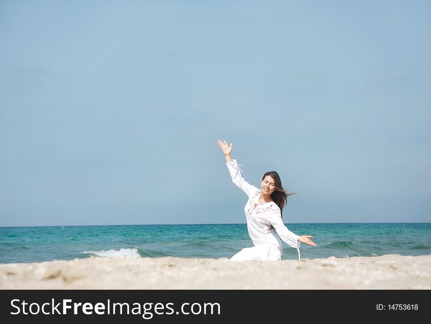 Young happy girl meditating on beach