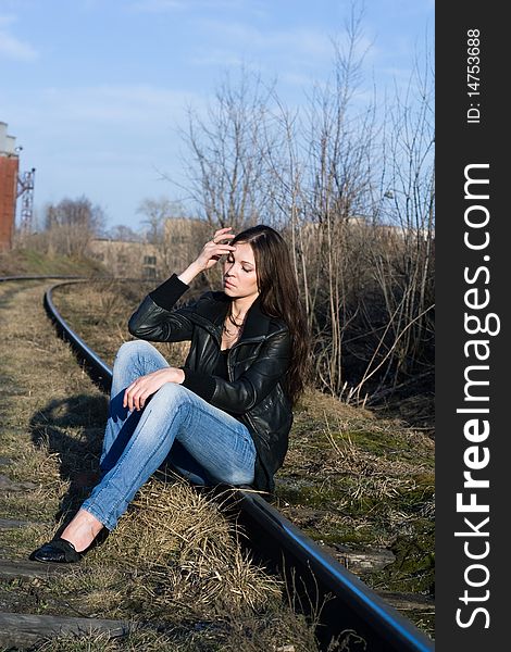 Depressive woman sitting on a railway track. Depressive woman sitting on a railway track