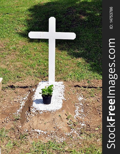 A little tomb with a white cross without name on it. A little tomb with a white cross without name on it