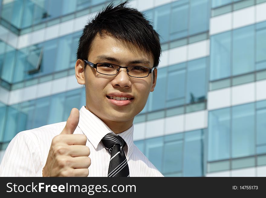 A young Asian business executive showing the thumbs up