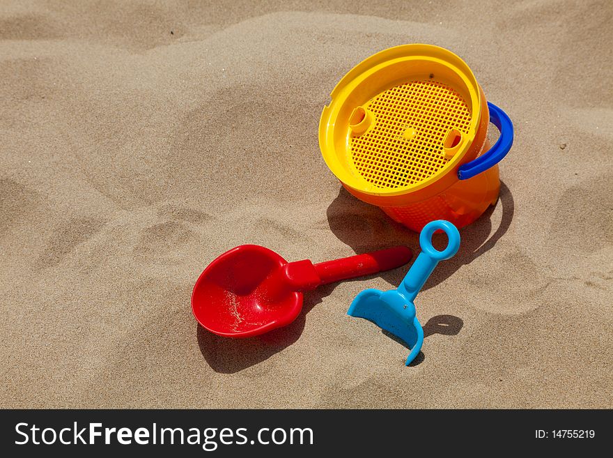 Children's beach toys - buckets, spade and shovel on sand on a sunny day. Children's beach toys - buckets, spade and shovel on sand on a sunny day