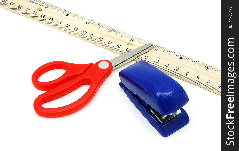 Wooden ruler with red-handle scissor and blue stapler. Wooden ruler with red-handle scissor and blue stapler