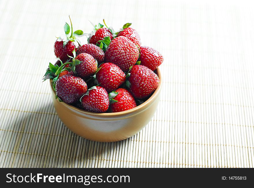 Ripe strawberries in ceramic bowl