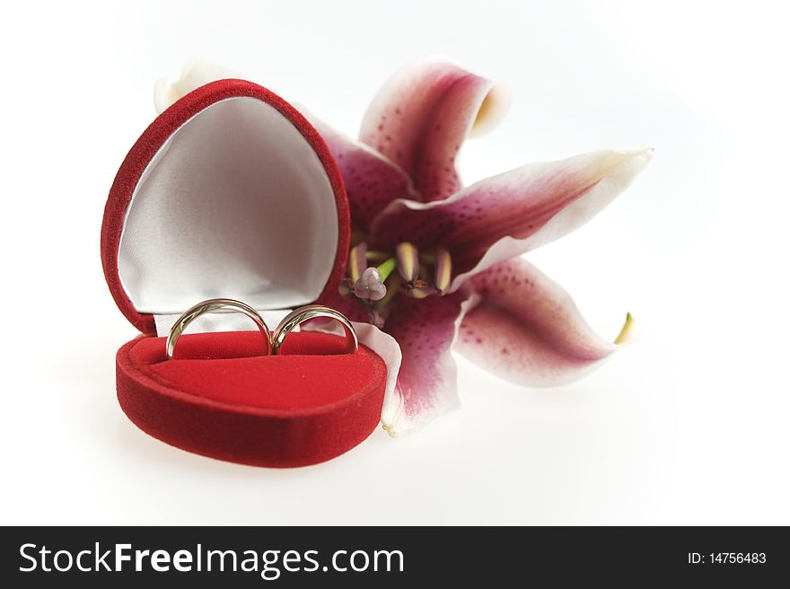 Matching rings in a heart shapped valvet box and in white background with tiger lily. Matching rings in a heart shapped valvet box and in white background with tiger lily
