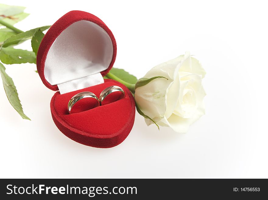 Matching rings in a heart shapped valvet box and in white background with white rose. Matching rings in a heart shapped valvet box and in white background with white rose