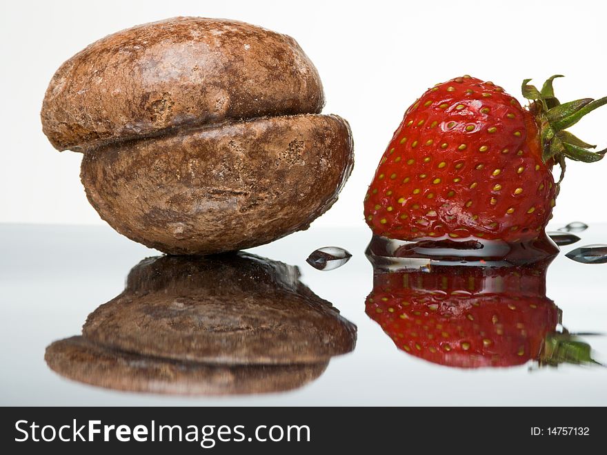 Honey cake and wet fresh strawberry on reflective surface