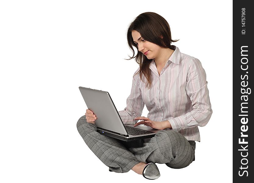 The beautiful girl sits on a floor with the laptop in a lap. The beautiful girl sits on a floor with the laptop in a lap